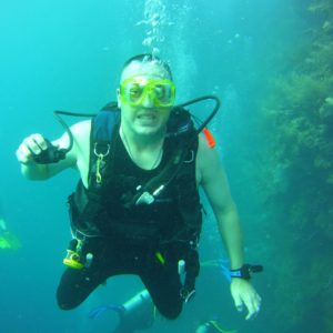 Photo of scuba diver, Charles Green diving next to a reef wall.